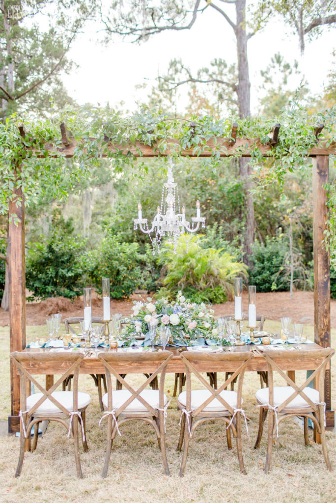 Rustic outdoor wedding table with hanging greenery